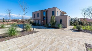 Een modern herenhuis met ruime oprit en aangelegde tuin.