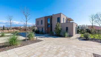 Een modern herenhuis met ruime oprit en aangelegde tuin.