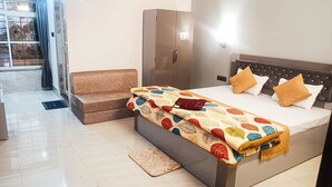 A hotel room with a bed, a sofa, a wardrobe, and a view of the outside. - Nature Green Resort (Mal)
