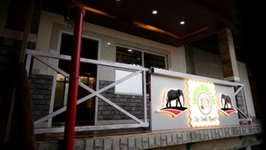 A building with a sign that reads "FRESHLY BREWED CUP" and features of a building with a stone facade and a wooden ceiling. - Nature Green Resort (Mal)