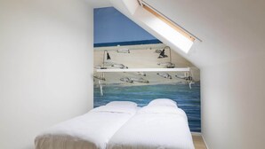 A bedroom with a bed, a skylight, and a wall mural of a beach scene. - Holiday Home in Nes near Vleijen Area (Nes)