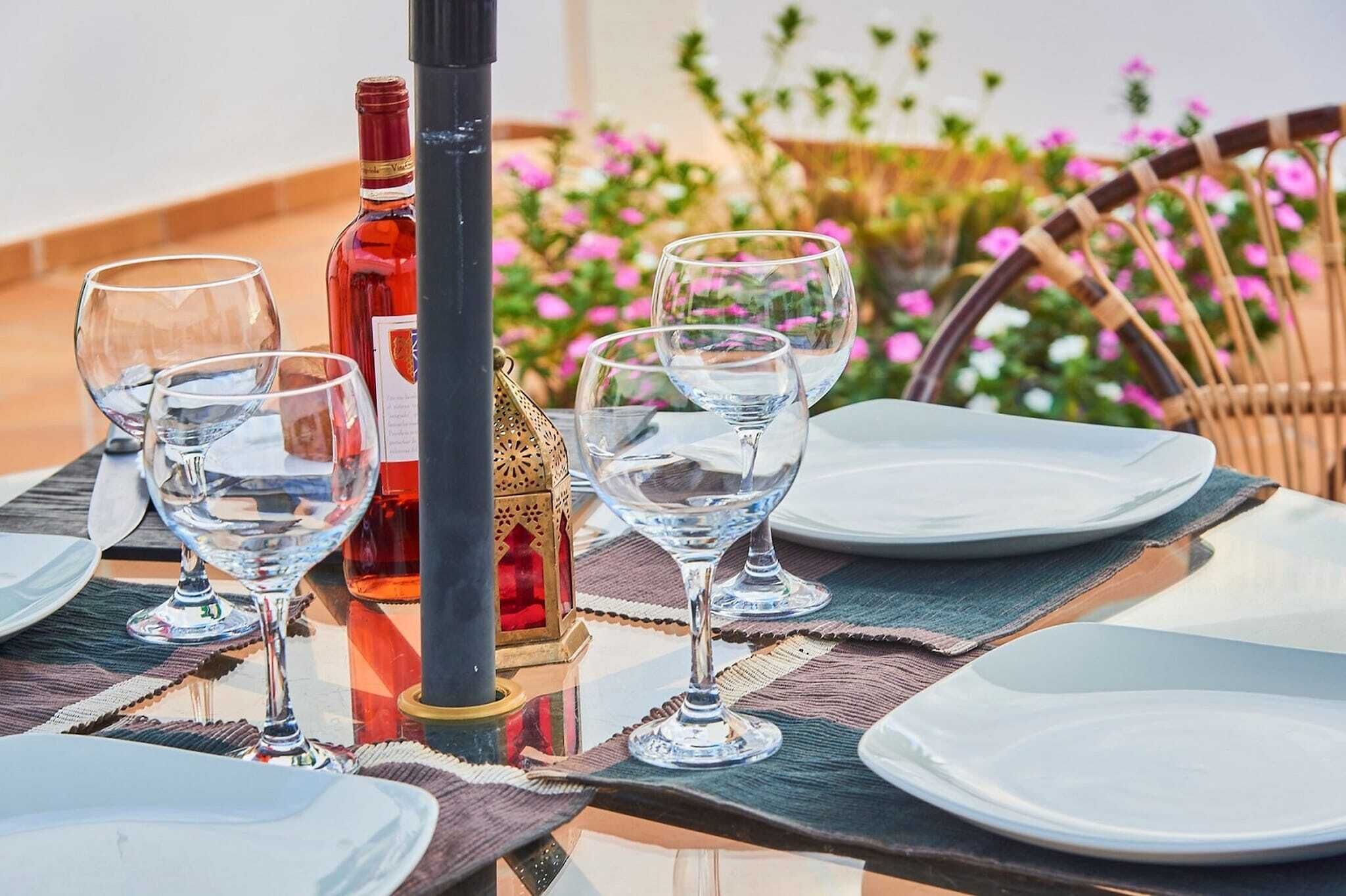Une table mise pour le dîner, avec des verres à vin, une bouteille et un objet décoratif.