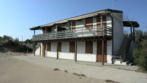 En toetagers bygning med balkon, trappe og flagstang.