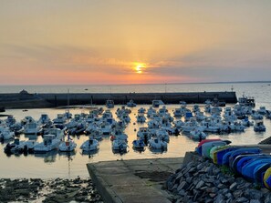 A marina with numerous boats docked at sunset.