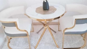 A white, round table with a gold base surrounded by two white armchairs with gold trim. - Lux suites Jimka Apartments Kisumu (Kisumu)