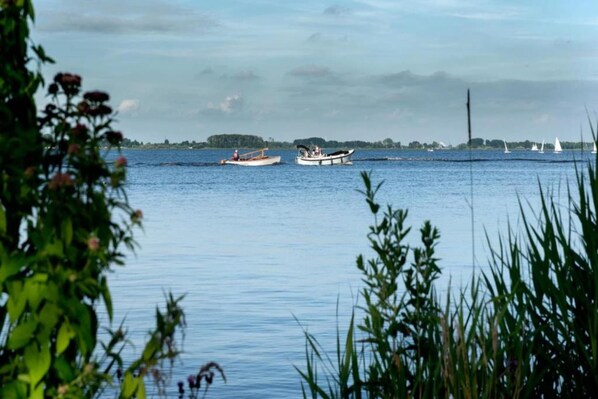 A calm lake with boats and sailboats.