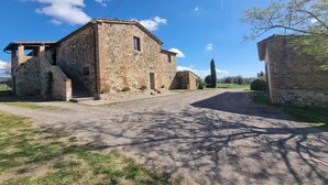 A stone building with a gravel driveway and a clear sky.