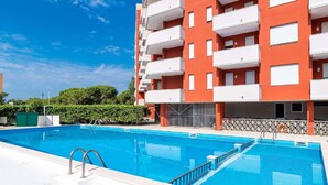 A modern apartment building with a swimming pool in front. - Holiday Home in Caorle near Spiaggia Tartaruga (Porto Santa Margherita (VE))