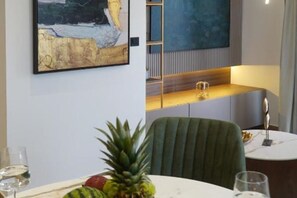 Un coin repas avec une table, des chaises et un tableau accroché au mur.