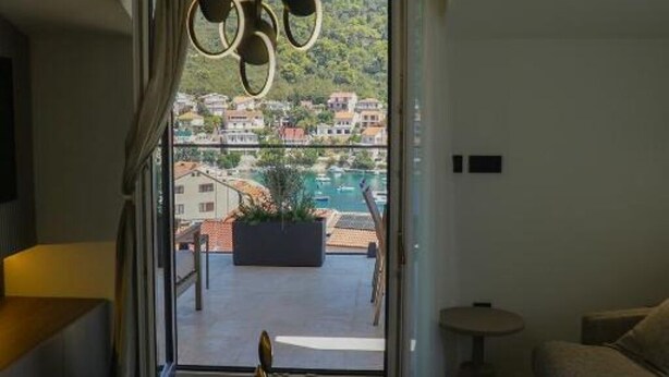 Ein modernes Zimmer mit großem Fenster und Blick auf einen Hafen und Gebäude.