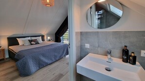 A bedroom with a bed, bedside table, and a hanging light fixture. - Water Villa in Balk with Private Jetty (Balk)