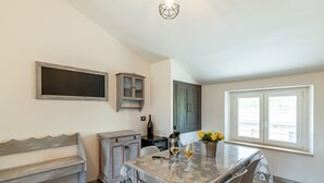 A dining area with a table set for two, a bench, and a cabinet. - Country escape in Matelica (Matelica)