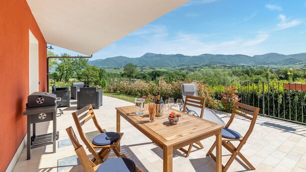 A wooden table with four chairs, a grill, and a view of mountains. - Country escape in Matelica (Matelica)