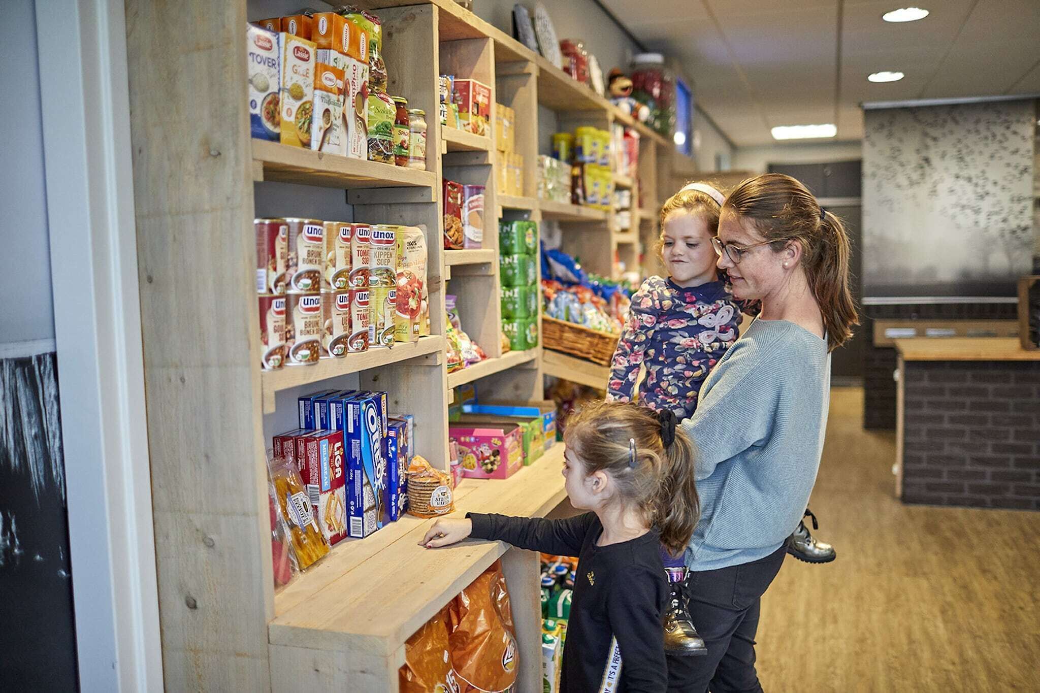 Interieur van een supermarkt met schappen vol diverse etenswaren.