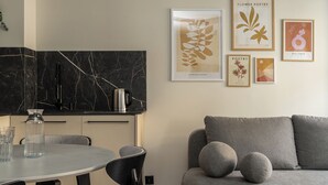 A modern living room with a grey sofa, a round coffee table, and a dining area with a marble countertop. - RentPlanet - Apartament Szczytnicka (Wroclaw)