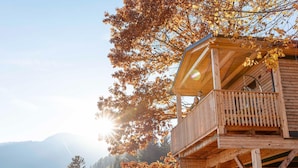 A wooden cabin with a balcony, surrounded by autumn trees and mountains in the background. - Chalet in Kötschach near Ski Area Vorhegg (Kötschach-Mauthen)