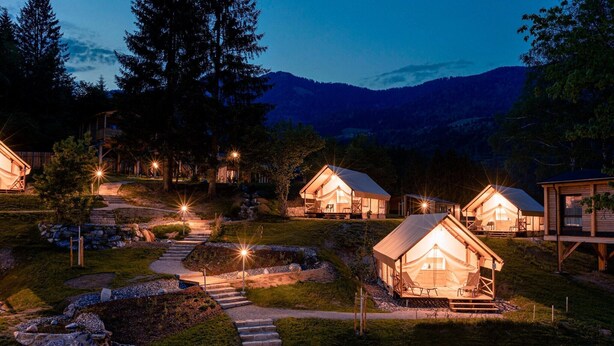 A series of wooden cabins with a stone pathway leading to them, surrounded by trees and hills. - Chalet in Kötschach near Ski Area Vorhegg (Kötschach-Mauthen)