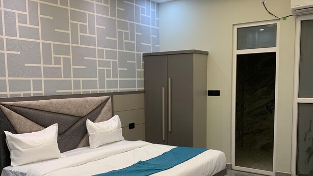 Un dormitorio moderno con cama, mesitas de noche, armario y ventilador de techo.