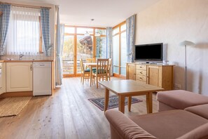 A compact living space with a kitchenette, dining area, and seating.