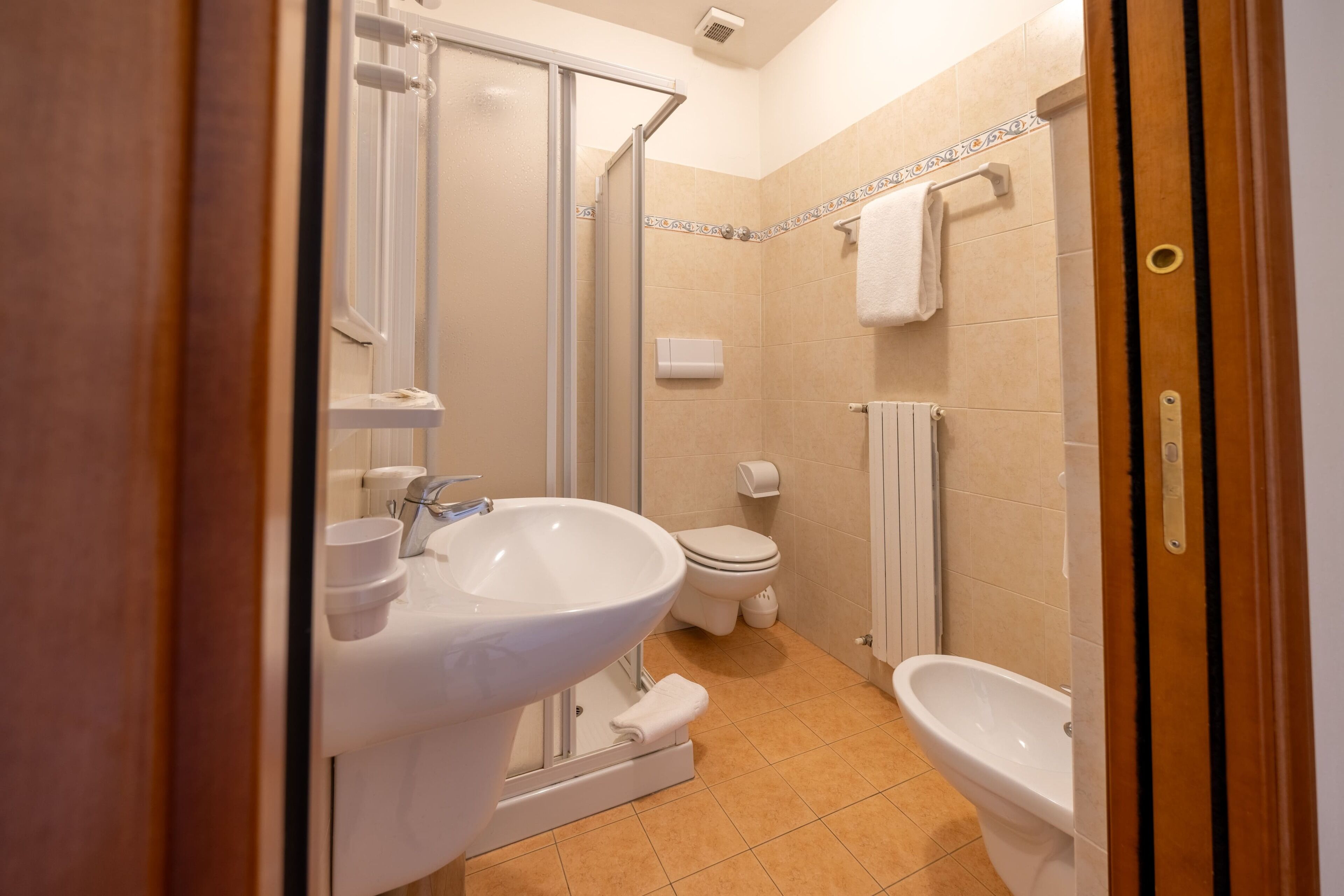 Une salle de bain équipée d’une douche, de toilettes, d’un lavabo et d’un bidet.