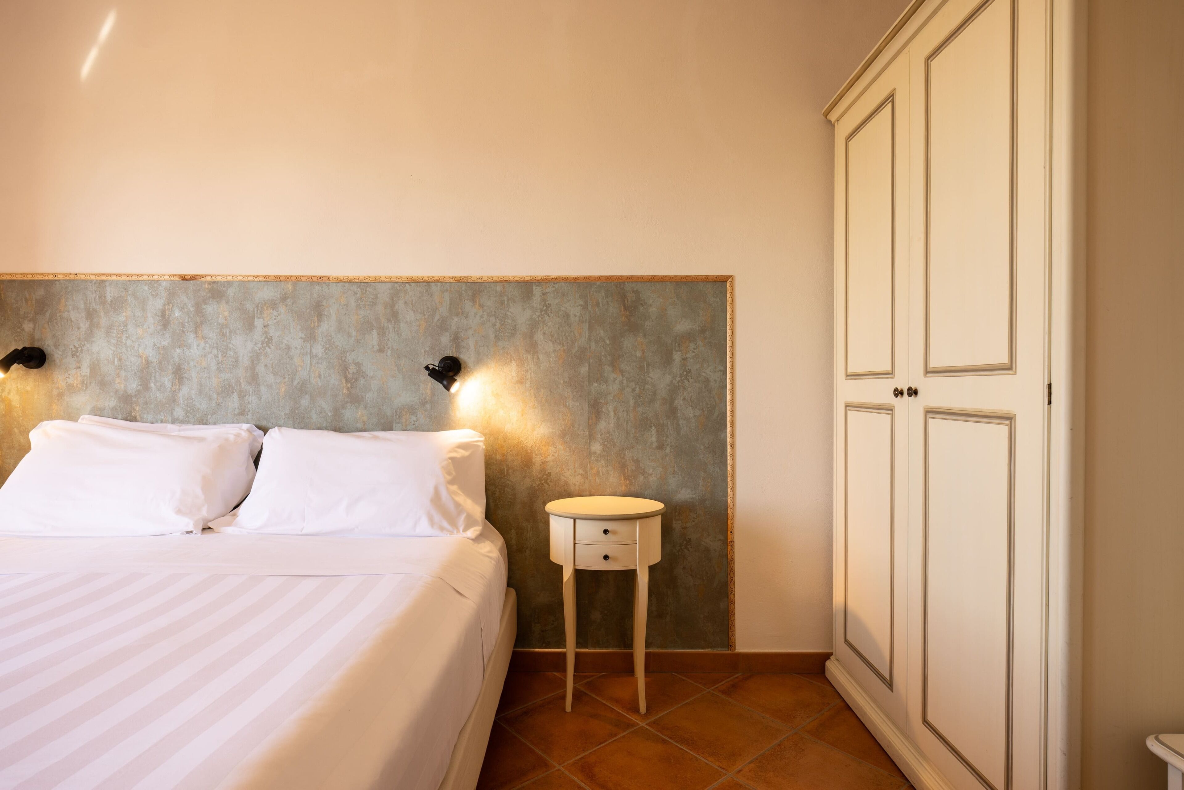 Ein Hotelzimmer mit Bett, Nachttisch und Kleiderschrank.