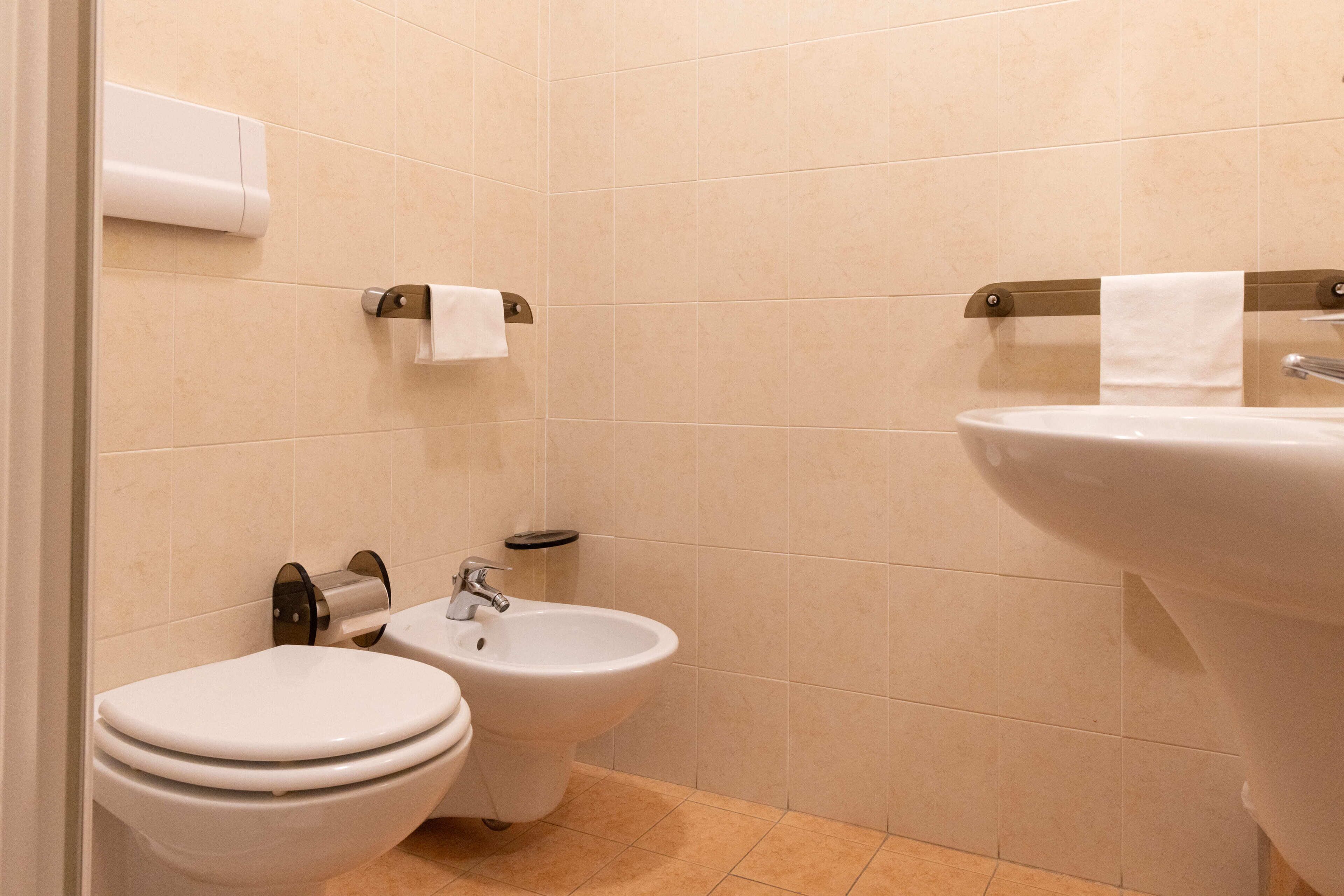 A bathroom with a toilet, bidet, and sink.
