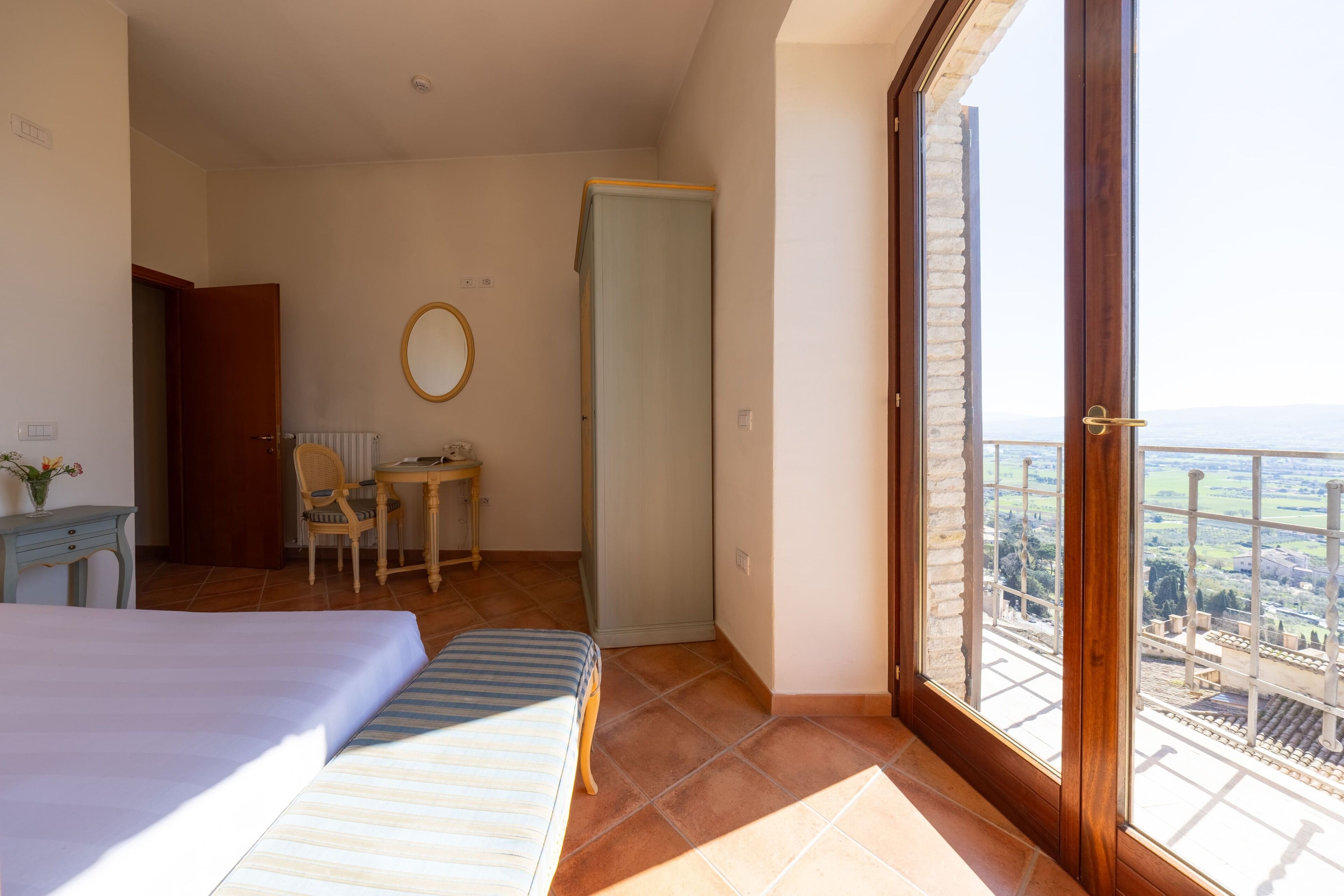 Una camera da letto con un letto, una sedia, una scrivania e vista attraverso una grande finestra.
