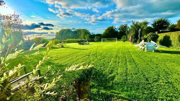 A well-maintained lawn with a goalpost and a blue chair.