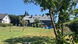 A residential area with a house, a lawn, and a tree with fruit.