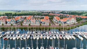 A marina with numerous boats docked, surrounded by traditional houses with red roofs and white facades. - Stylish Stay in Volendam (Volendam)