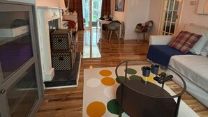 Una sala de estar acogedora con un sofá, una mesa de centro y un área de comedor al fondo.