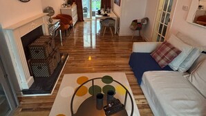 Una sala de estar moderna con chimenea, comedor y sofá.