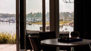 A view from a room with large windows overlooking a marina with boats and a lake.