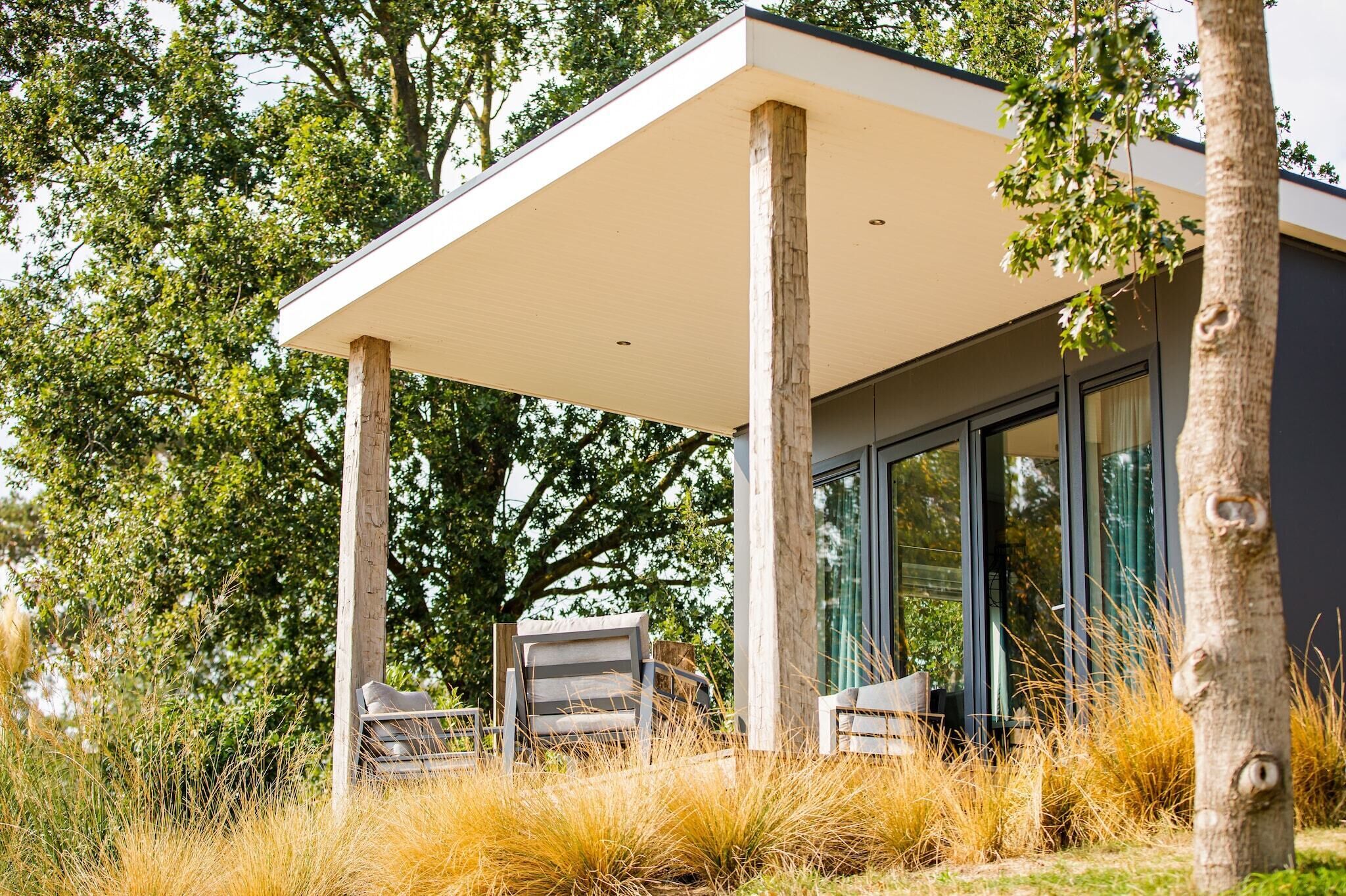 A modern building with a covered patio area, large windows, and outdoor seating.