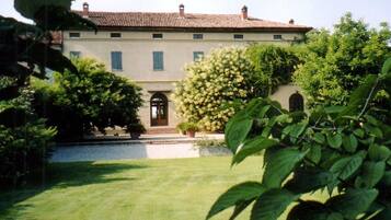 Un edificio grande su due piani, con facciata simmetrica, un ingresso centrale con porta e un piccolo balcone sopra l'ingresso.