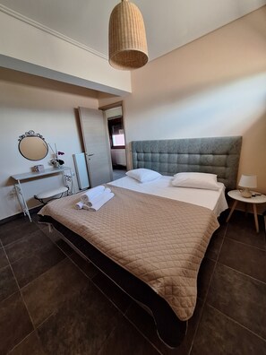 Ein ordentlich eingerichtetes Schlafzimmer mit Bett, Nachttisch, Lampe und Spiegel.