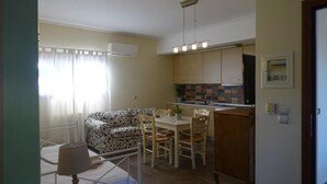 A compact living space with a kitchenette, a dining area, and a sofa. - Naiad Studio Sea View (Poros)