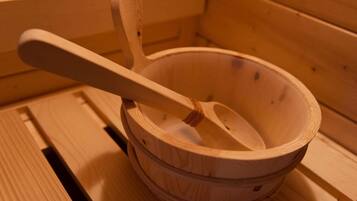 A wooden bowl with a spoon inside, placed on a wooden surface.