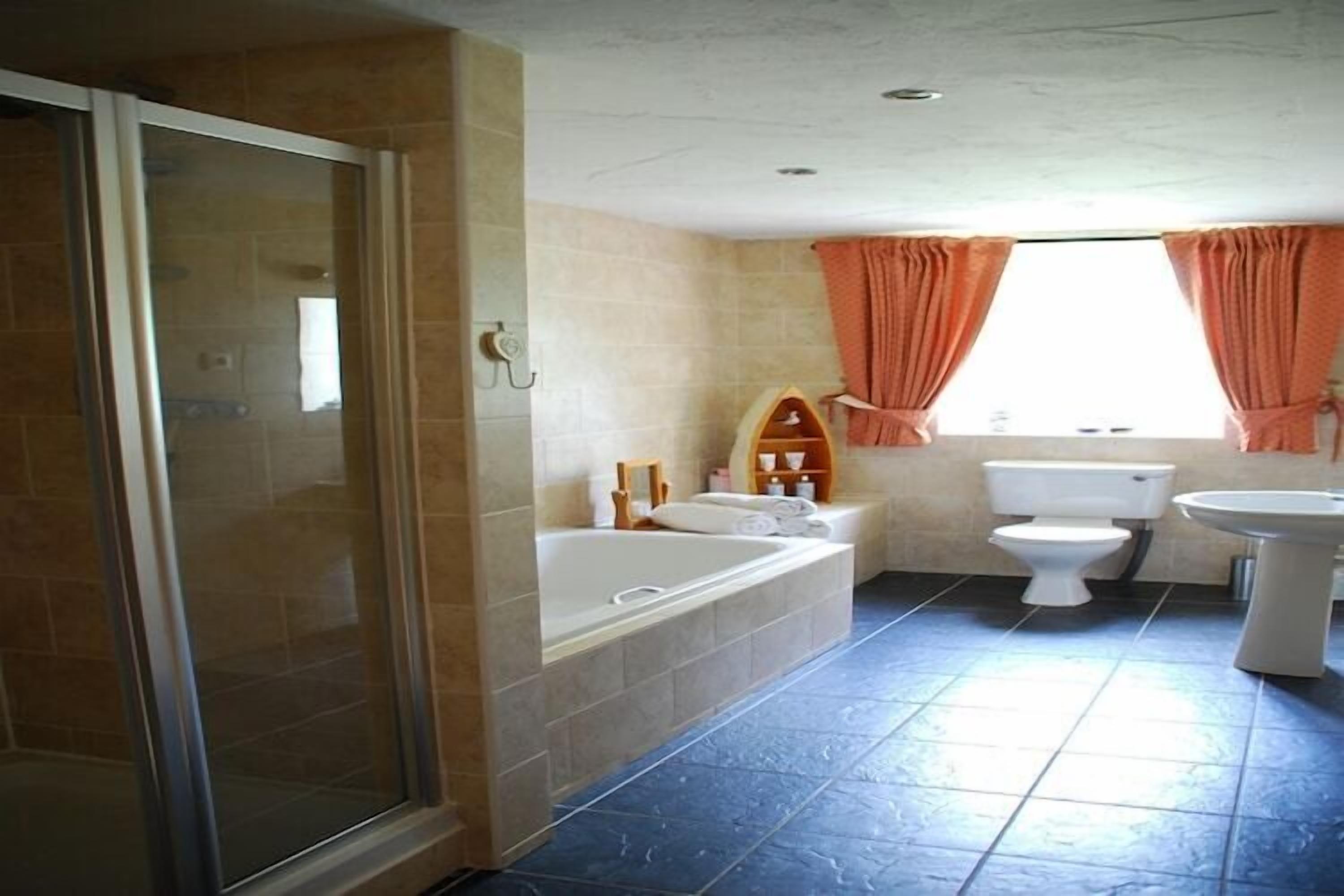 Ein Badezimmer mit Duschkabine, Badewanne, Toilette und Waschbecken.