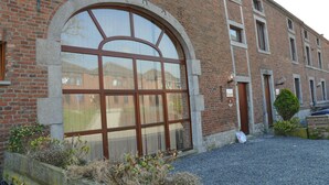 Um edifício de tijolos com uma grande janela em arco e várias janelas menores.