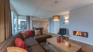 Una sala de estar moderna con un sofá seccional, una mesa de centro y una chimenea.
