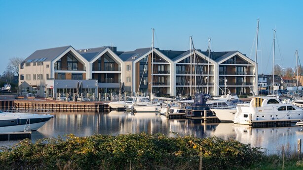 A marina with modern buildings and boats docked. - Stylish Marina Loft w/Balcony (Kamperland)