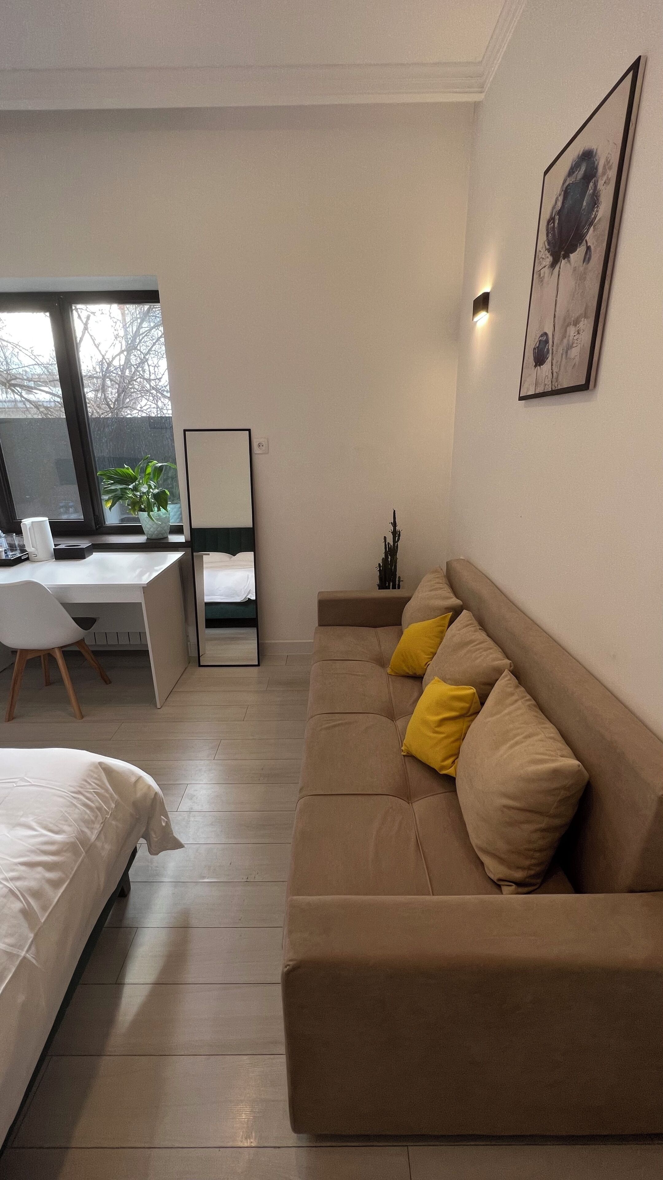 A modern bedroom with a bed, a desk, and a sofa.