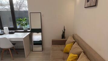 A modern bedroom with a bed, a desk, and a sofa.