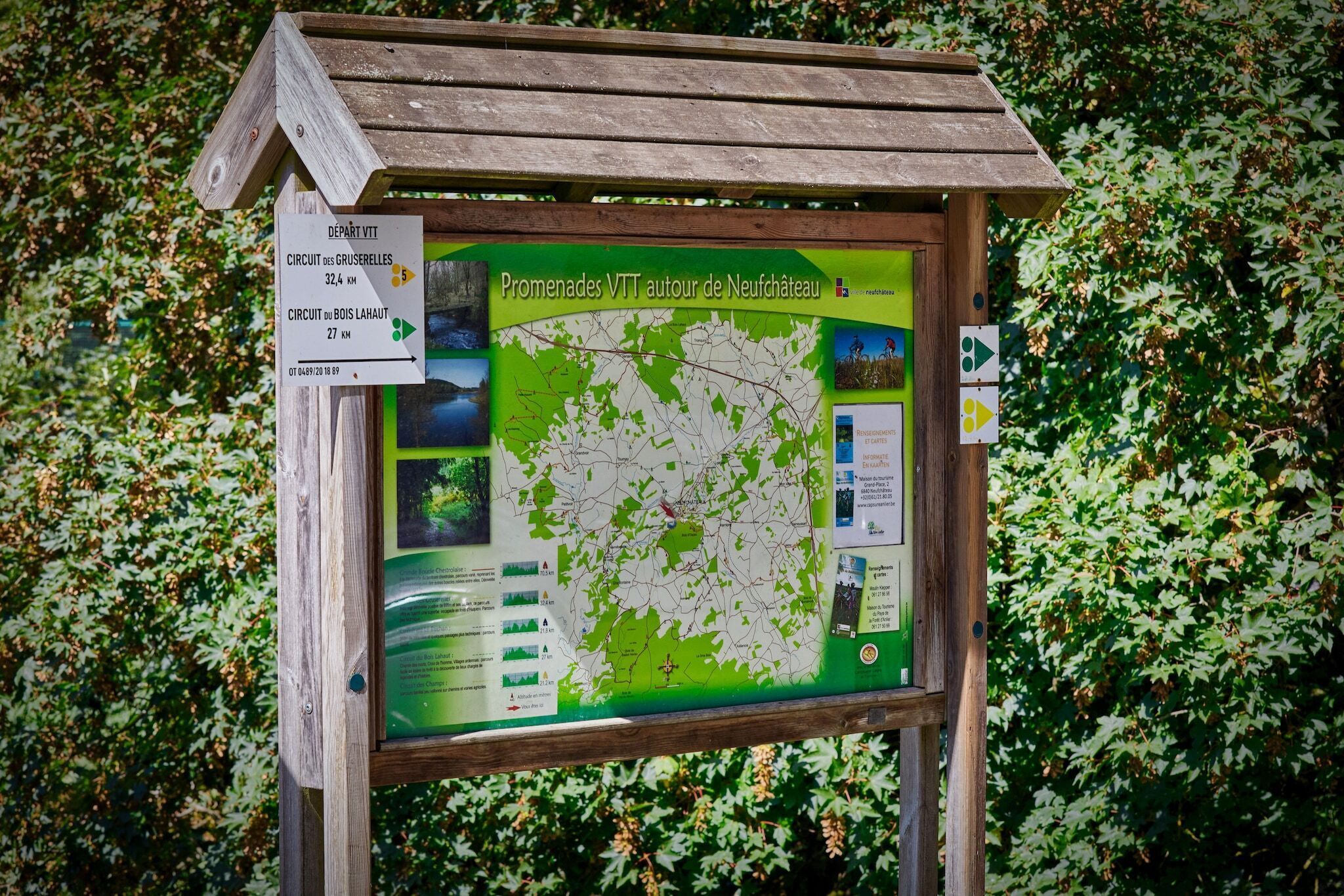 A wooden signpost with a map and directional information for hiking trails.