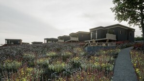 A modern residential complex with multiple houses, a pathway, and a variety of flowering plants. - Cozy Luxembourg Apartment (Neufchâteau)