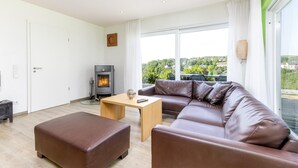 Ein modernes Wohnzimmer mit einem braunen Ledersofa, einem Holztisch und einem Kamin.