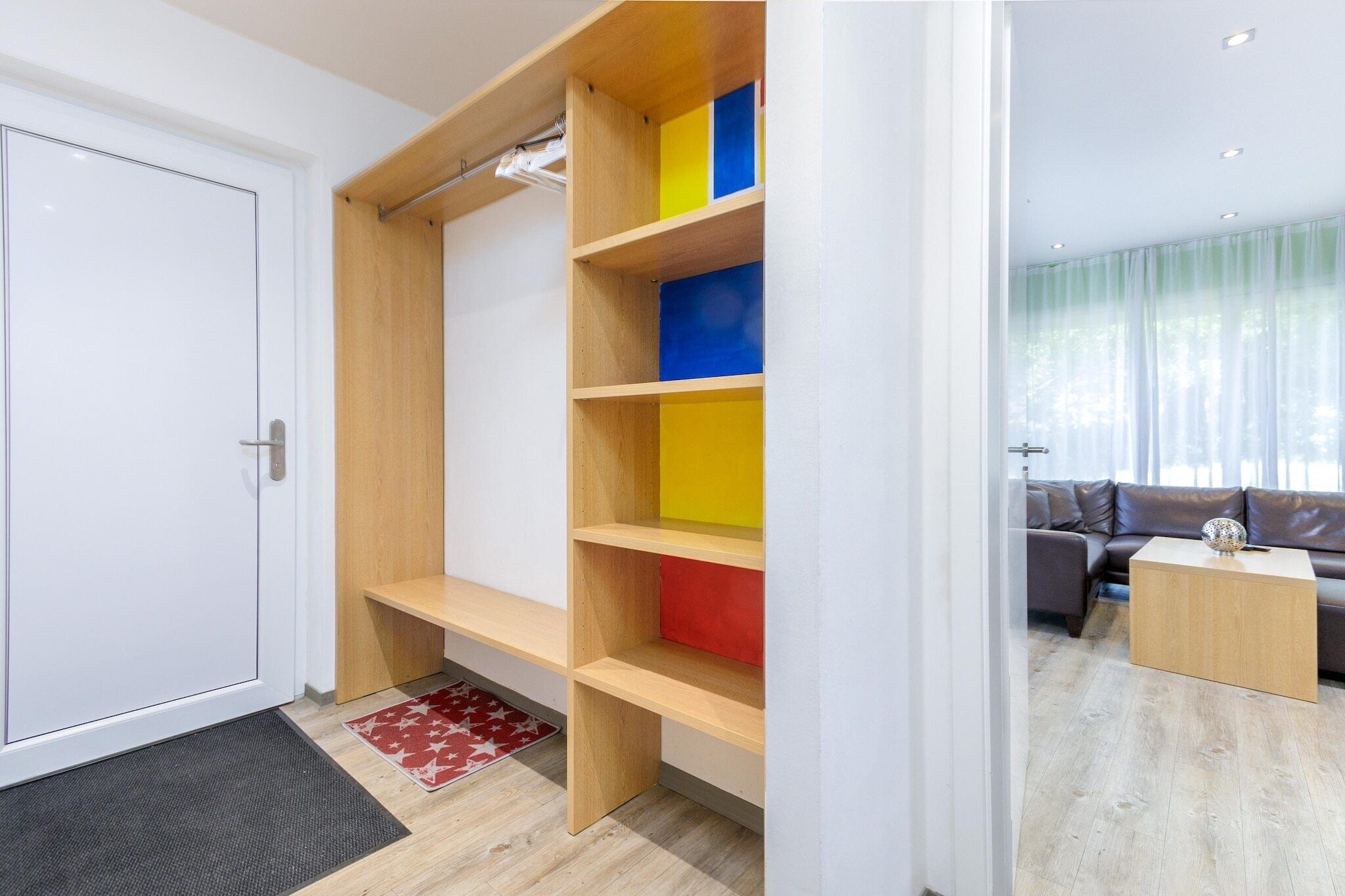 En modern inredning med en hyllsektion i trä, en soffa och ett soffbord.