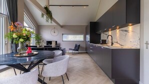 Une cuisine moderne avec des meubles de couleur sombre et un plan de travail en marbre.