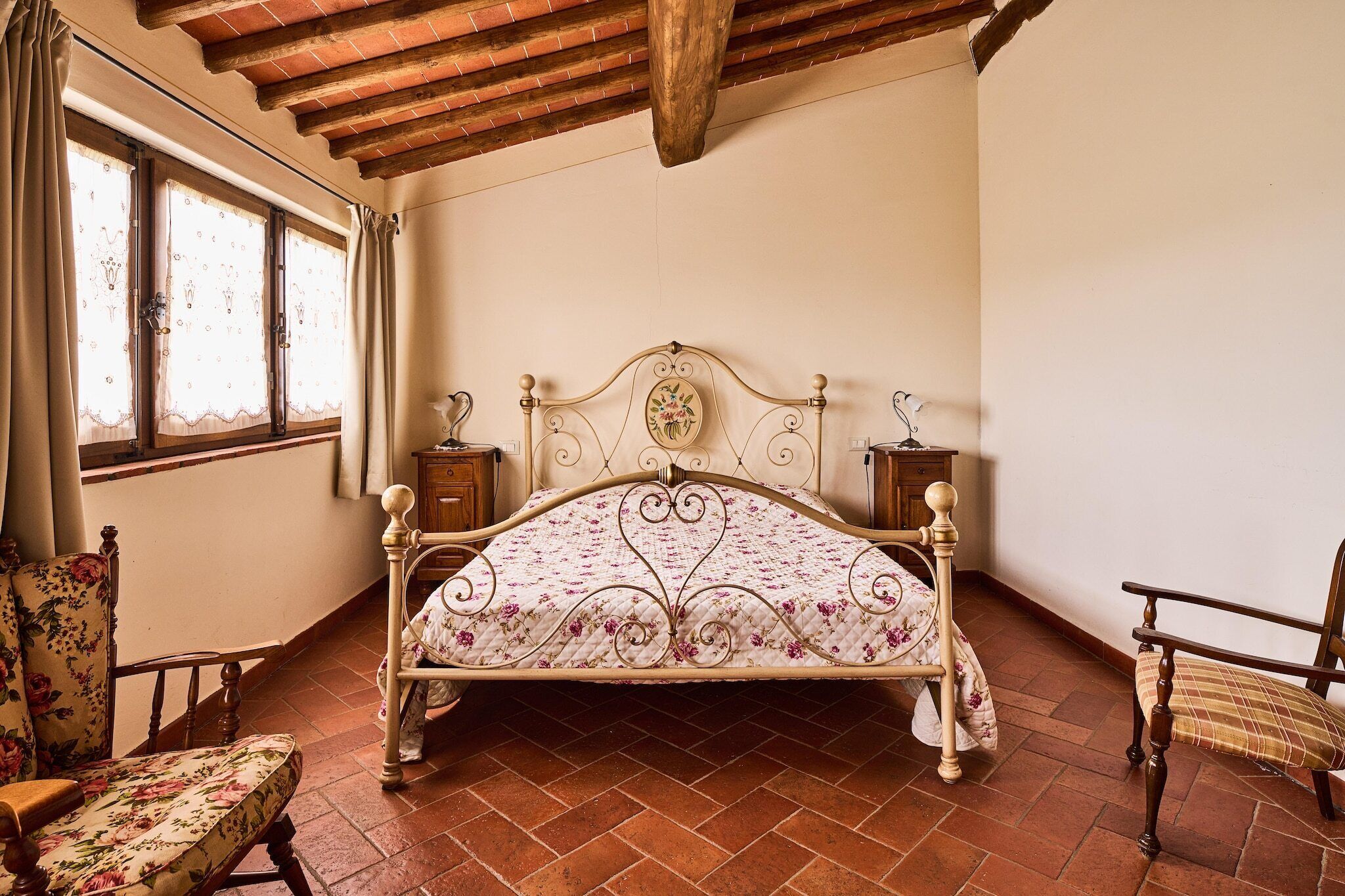 Une chambre à coucher avec un lit en bois, une chaise et une table de chevet.